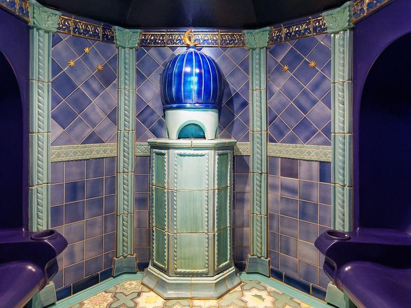 Un intérieur luxueux avec un siège violet et une petite fontaine bleue, ambiance apaisante.
