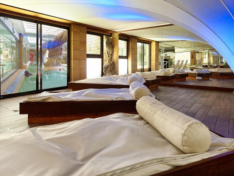 Intérieur d'une salle de relaxation avec lits allongés et lumière bleue douce.