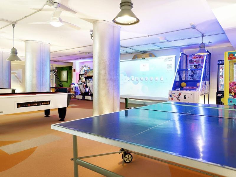 Salle de loisirs avec baby-foot, ping-pong et éclairage moderne dans un hôtel.