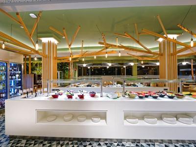 Moderner Buffetbereich mit hellem Tresen, Holzsäulen und gekühlten Getränkeregalen links.