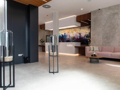 Nowoczesny hol hotelowy z eleganckimi meblami, ozdobionymi ścianami i miękkim oświetleniem.