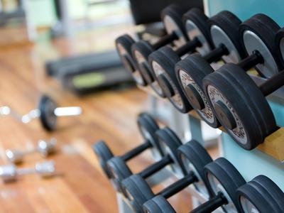 Primer plano de mancuernas en gimnasio con suelo de madera