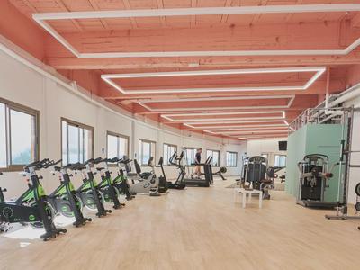 Gimnasio moderno con bicicletas y máquinas de fuerza en una habitación amplia y luminosa.