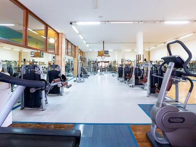 Gimnasio luminoso con equipos modernos, espejos y espacio abierto.