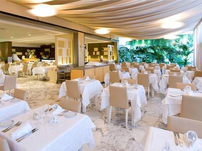 Elegancka restauracja na świeżym powietrzu z białymi obrusami i wygodnymi krzesłami pod markizą.