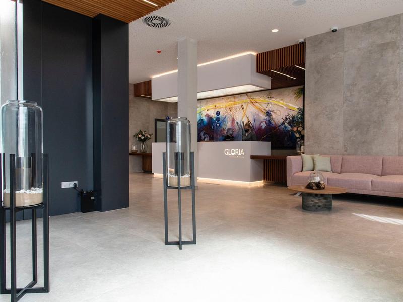 Nowoczesny hol hotelowy z eleganckimi meblami, ozdobionymi ścianami i miękkim oświetleniem.