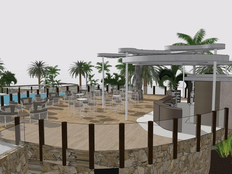 Tropikalny basen na zewnątrz z leżakami, palmami i zacienionym pawilonem przy oceanie.