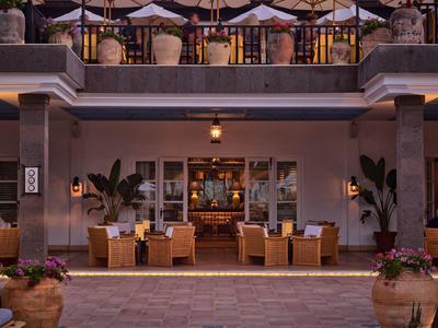 Gemütliche Außenterrasse mit Holztischen, Stühlen und Sonnenschirmen in einem eleganten Restaurant.