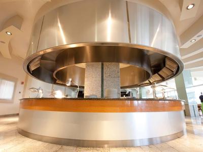 Moderne ontbijtruimte met ronde uitnodigende buffet en lichte binnenruimte.