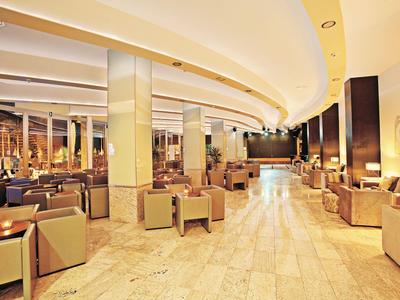 Bright, modern hotel lobby area with comfortable armchairs and warm lighting.