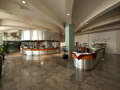 Modern hotel lobby area with large counters, marble flooring, and subdued lighting.