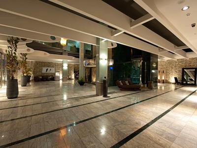 Ruime moderne hotellobby met marmeren vloeren en stijlvolle verlichting.