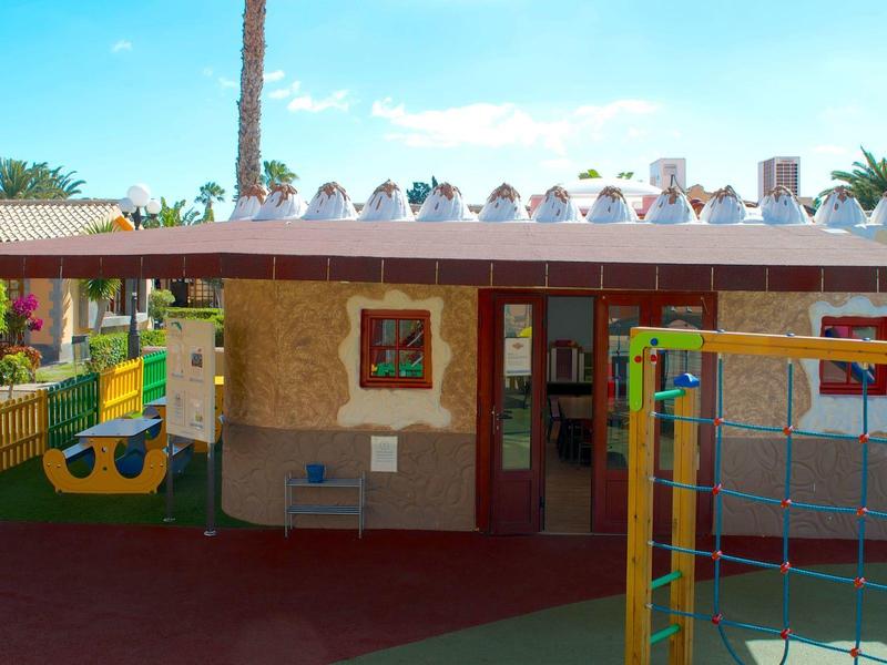 Aire de jeux colorée pour enfants avec structure d'escalade et mur en pierre par une journée ensoleillée