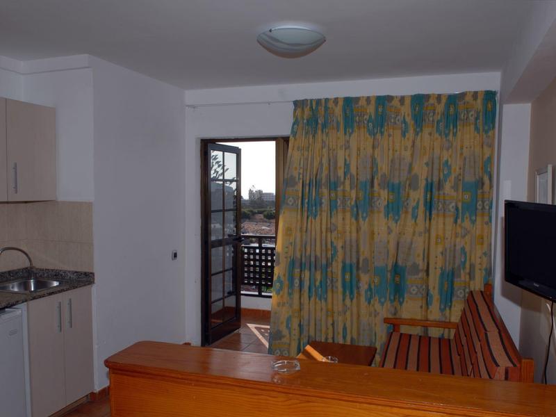 Modern hotelkamer met kitchenette en balkon met uitzicht naar buiten.