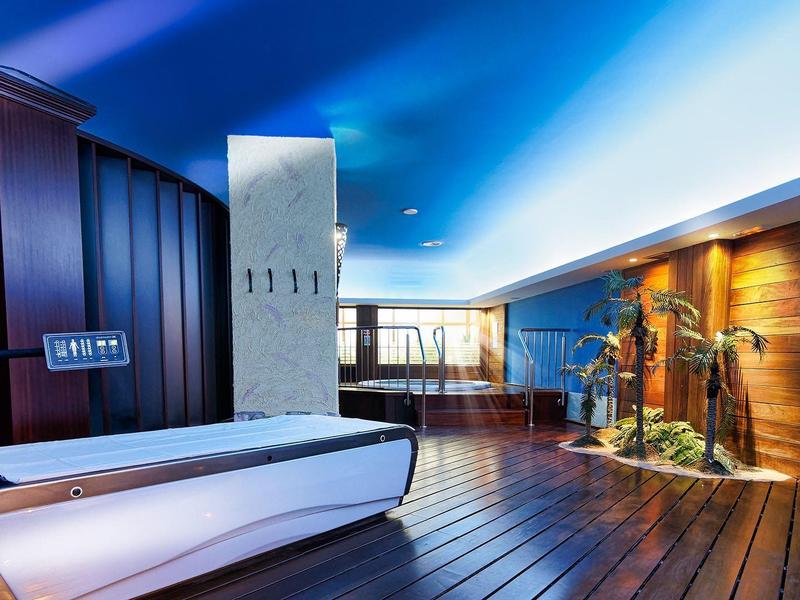 Moderner Innenraum mit hölzernen Böden, blauer Beleuchtung und stilvoller, weißer Lounge-Couch.