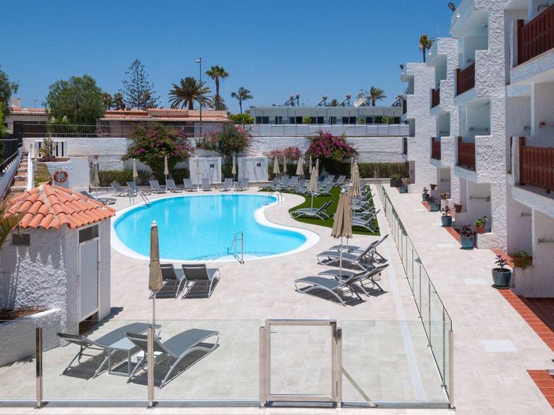 Hotel zwembadgebied met ligstoelen en parasols buiten op een zonnige dag