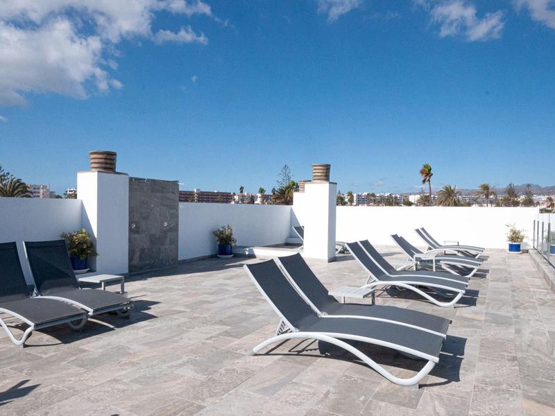 Recreatiegebied met meerdere ligbedden op een terras bij zonnig weer