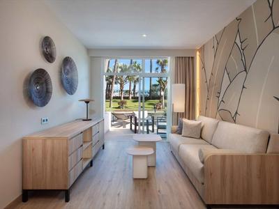 Moderní obývací pokoj s pohovkou, komodou a výhledem na terasu a zahradu.