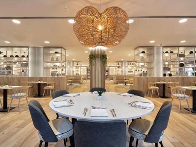 Elegantní restaurace s kulatým stolem, moderními židlemi a unikátní lampa ve tvaru srdce.