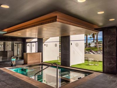 Moderní vnitřní bazén s velkým oknem a dřevěným stropem v hotelu