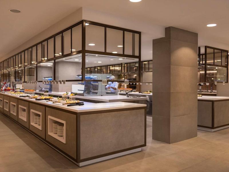 Moderní hotelová bufetová stanice s rozmanitým jídlem a stylovým interiérem.