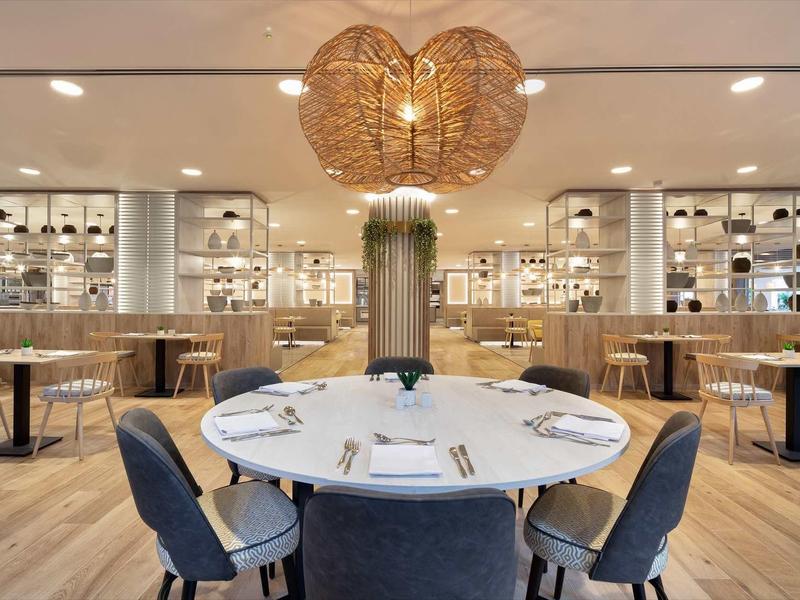 Elegantní restaurace s kulatým stolem, moderními židlemi a unikátní lampa ve tvaru srdce.