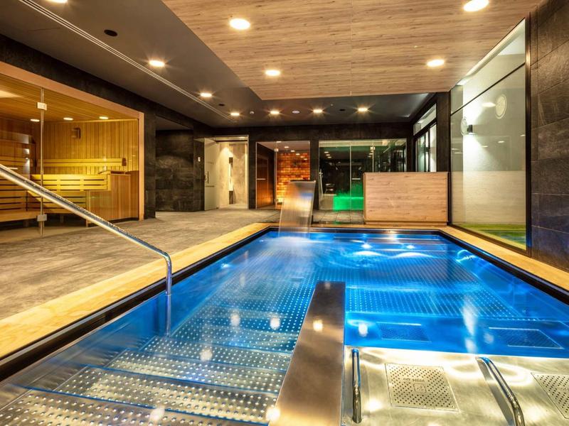Vnitřní prostor s moderním bazénem a uvolněnou atmosférou v hotelu.