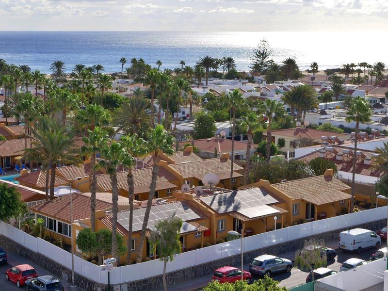 Vue d'un complexe hôtelier avec jardin de palmiers et mer en arrière-plan