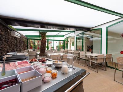 Interiér světlé snídaňové restaurace s moderním bufetem a posezením.