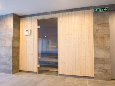 Moderne saunaruimte met houten bekleding en keramische tegels aan de muren.