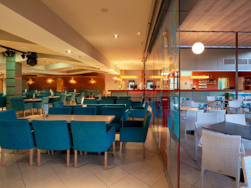 Stylish hotel dining area with teal and white chairs and warm lighting.