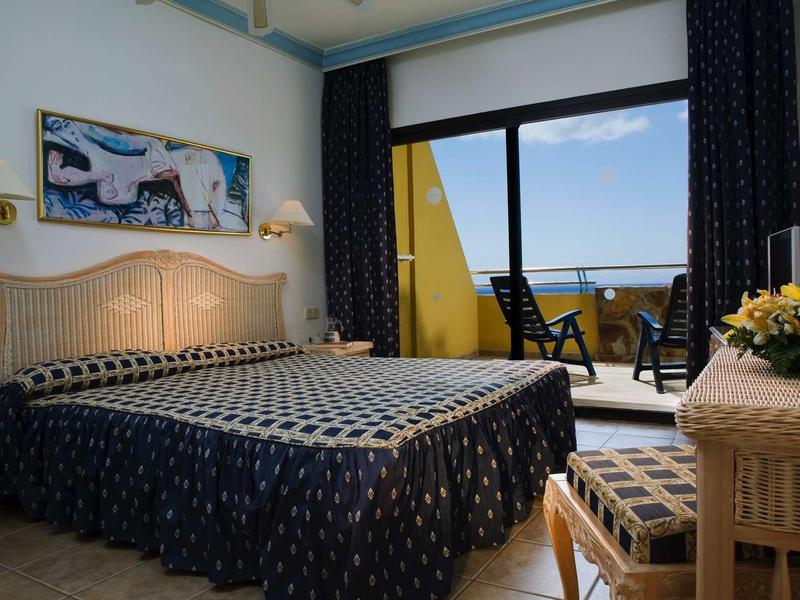 Camera d'albergo accogliente con letto matrimoniale e balcone con vista mare.