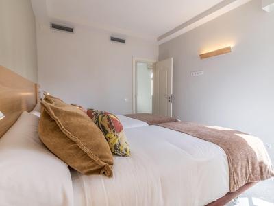 Camera d'hotel luminosa con letto grande, cuscini e coperte morbide.