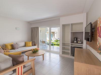 Soggiorno moderno con divani, TV e accesso alla terrazza in hotel.