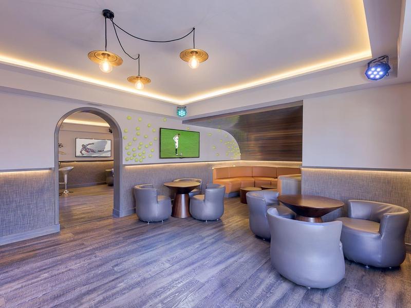 Area lounge dell'hotel moderna con poltrone rotonde e illuminazione discreta.