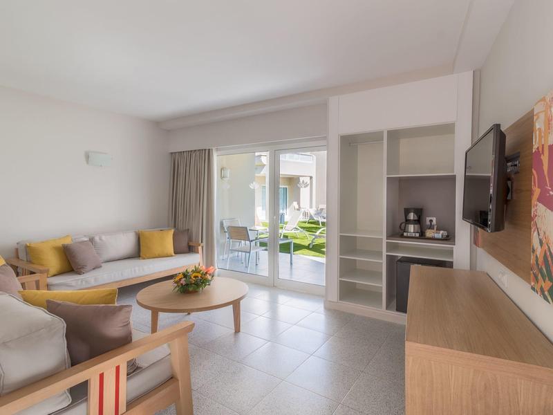 Soggiorno moderno con divani, TV e accesso alla terrazza in hotel.