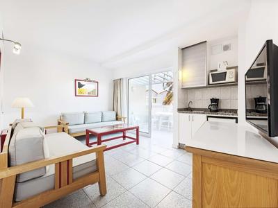 Appartement lumineux avec salon, cuisine et balcon dans un style moderne.