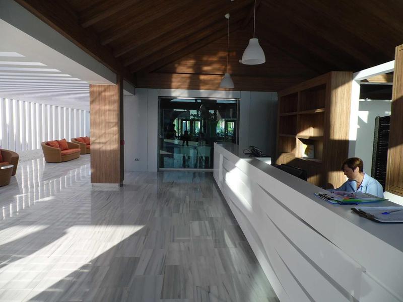 Nowoczesna recepcja hotelowa z wysokimi sufitami i dużą ilością światła naturalnego.