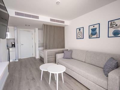 Soggiorno moderno con divano grigio, tavoli bianchi e arte astratta sulla parete