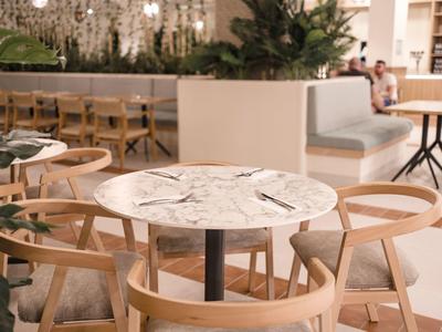 Area salotto moderna con piano in marmo e sedie in legno in un ristorante dell'hotel.