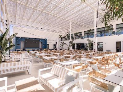 Ristorante luminoso e moderno con mobili bianchi e in legno e molta luce naturale.