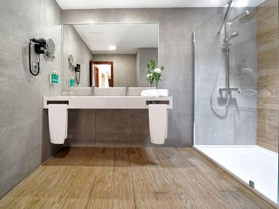 Salle de bain moderne avec douche à l'italienne et sol en bois.