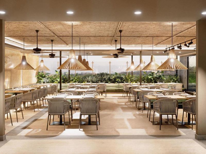 Restaurant moderne et lumineux avec mobilier en bois et plantes, atmosphère détendue.