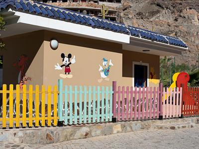 Buntes Kinderspielhaus mit Mickey- und Donald-Dekor und Solarzellen auf dem Dach.