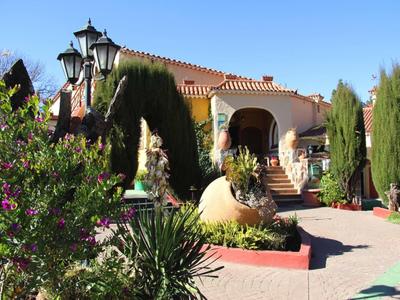 Casa con terrazza circondata da piante mediterranee sotto un cielo limpido.