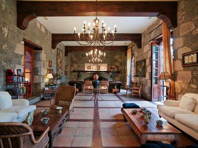 Salon élégant avec murs en pierre, lustres et sièges confortables dans un hôtel.