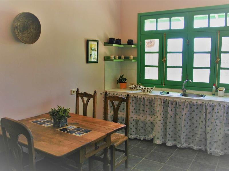 Lichte keuken met tafel, stoelen en raam met groene omlijsting