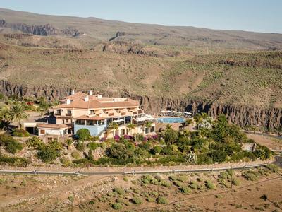 Grande hotel con piscina in un paesaggio asciutto e collinare circondato dalla natura.