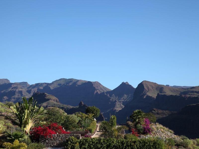 Ristorante elegante all'aperto con tavoli apparecchiati e ombrelloni al tramonto.