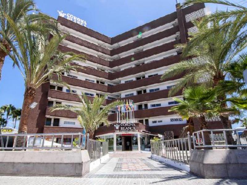 Bâtiment d'hôtel à plusieurs étages avec terrasse et palmiers à l'entrée